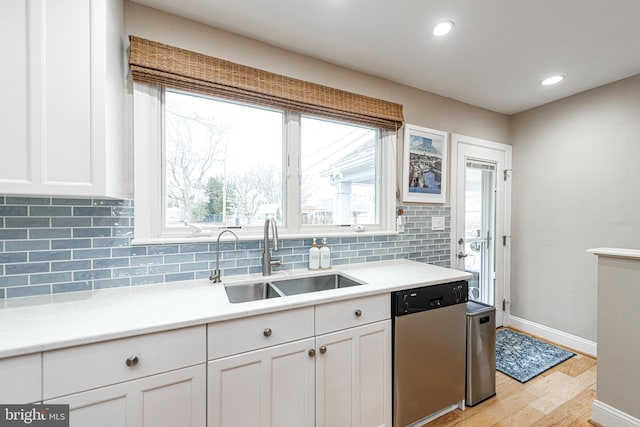 kitchen with white cabinetry, sink, backsplash, and stainless steel dishwasher