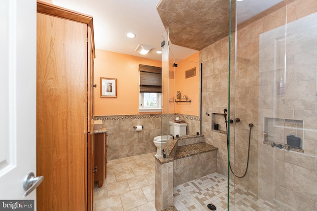 bathroom featuring vanity, tile walls, an enclosed shower, and toilet