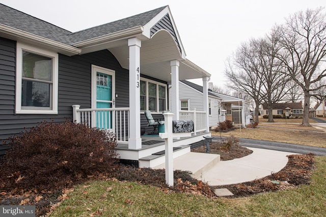 view of side of home featuring covered porch