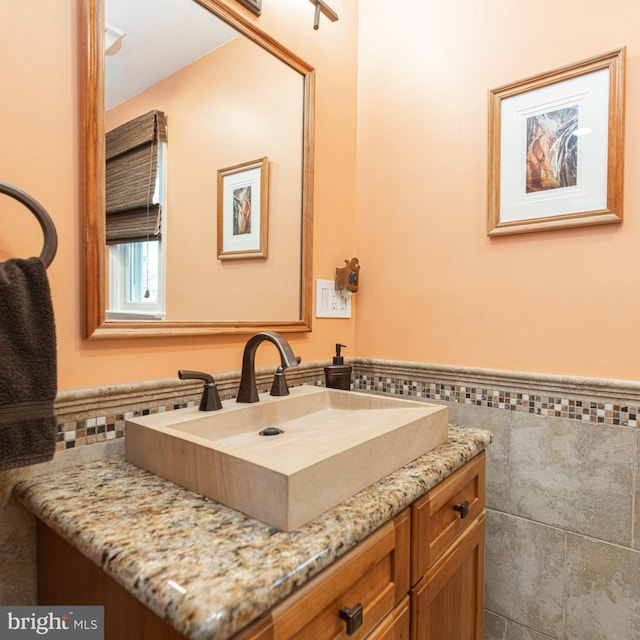 bathroom featuring vanity and tile walls