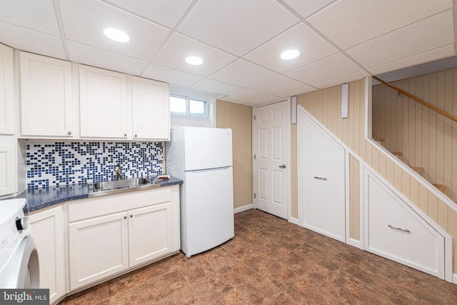 kitchen with washer / clothes dryer, sink, white cabinets, and white fridge