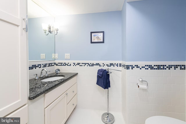 bathroom featuring vanity and tile walls