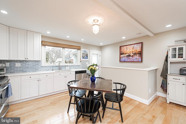 dining space with sink and light hardwood / wood-style floors