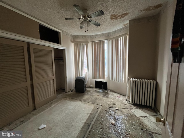 unfurnished bedroom featuring ceiling fan, radiator, a closet, and a textured ceiling