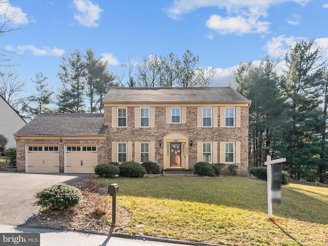 colonial house with a garage and a front lawn