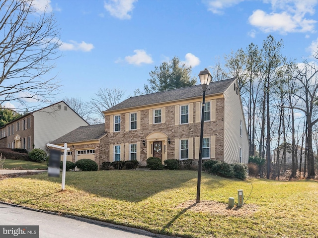 colonial-style house featuring a garage and a front yard