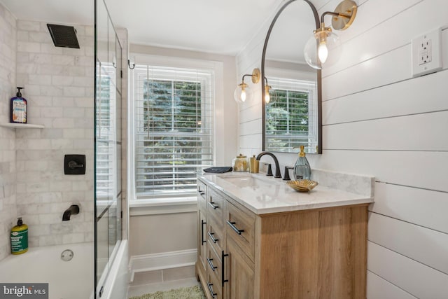 bathroom with tile patterned flooring, vanity, and combined bath / shower with glass door