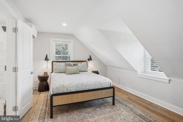 bedroom featuring wood-type flooring and vaulted ceiling