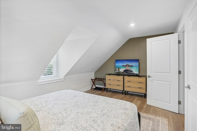 bedroom with lofted ceiling and wood-type flooring