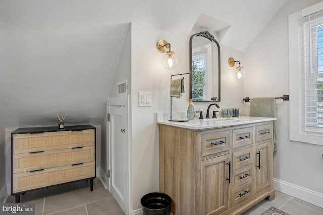 bathroom with a healthy amount of sunlight, vanity, and tile patterned flooring