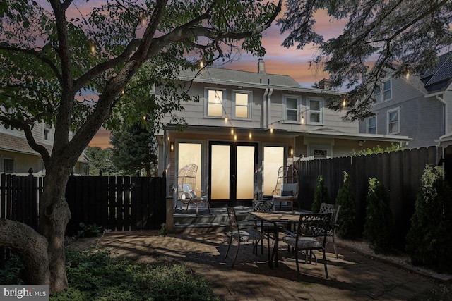 back house at dusk with a patio