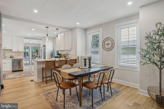 dining space featuring sink and light hardwood / wood-style flooring