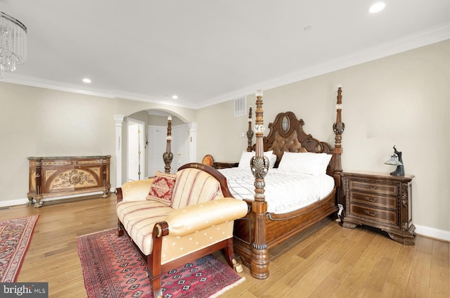 bedroom with crown molding and light hardwood / wood-style floors