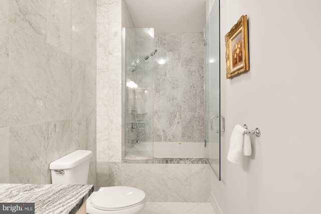 full bathroom featuring vanity, tile walls, shower / bath combination with glass door, and toilet