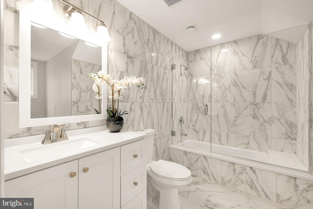 bathroom featuring tiled shower / bath, tile walls, and vanity