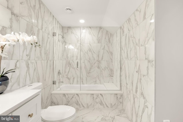 full bathroom with vanity, tiled shower / bath combo, tile walls, and toilet