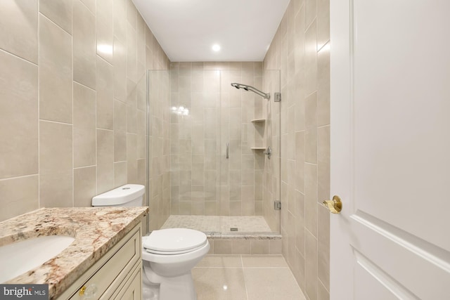 bathroom with tile patterned flooring, vanity, toilet, and a shower with shower door