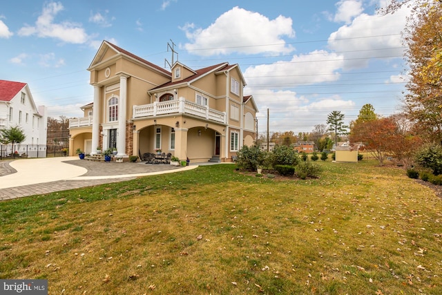 view of front of property with a front yard and a balcony