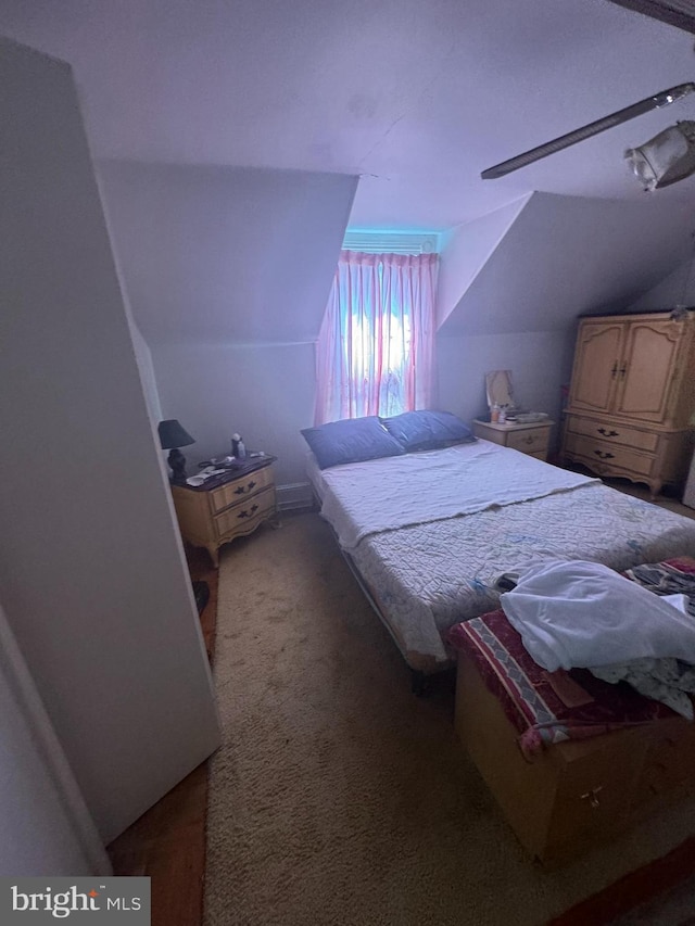 bedroom featuring lofted ceiling and dark colored carpet