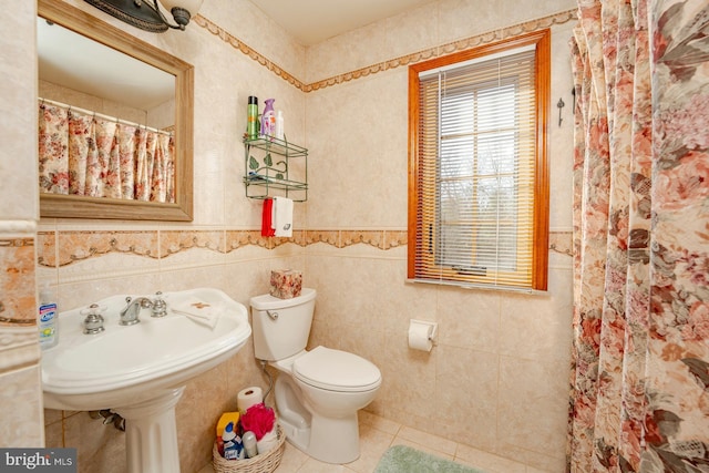 bathroom featuring tile patterned flooring, toilet, tile walls, and walk in shower