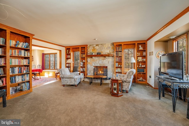 carpeted living room featuring ornamental molding, a stone fireplace, and built in features