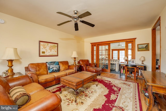 living room featuring light hardwood / wood-style flooring, french doors, ceiling fan, and vaulted ceiling