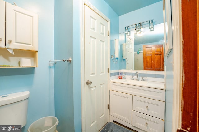 bathroom with vanity, backsplash, and toilet