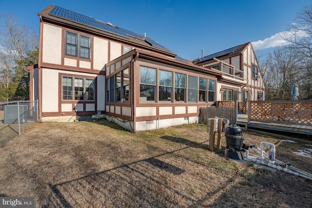 back of property featuring central AC unit, a yard, a balcony, and solar panels