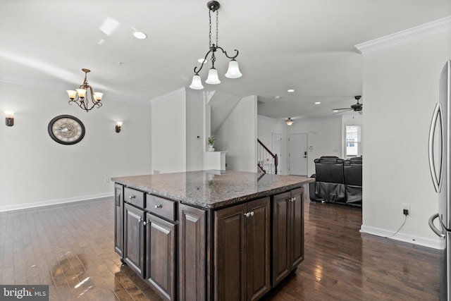 kitchen with dark wood-style floors, dark brown cabinetry, and ornamental molding