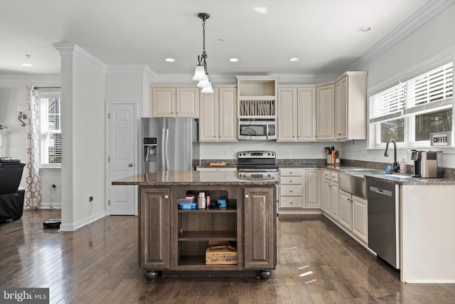 kitchen featuring open shelves, cream cabinetry, appliances with stainless steel finishes, and a sink