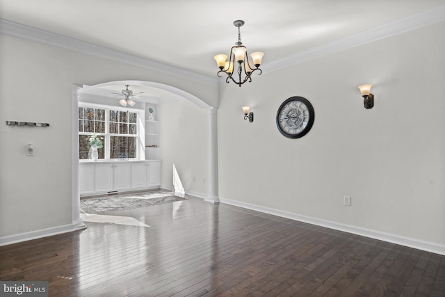 unfurnished dining area with arched walkways, crown molding, baseboards, and hardwood / wood-style flooring