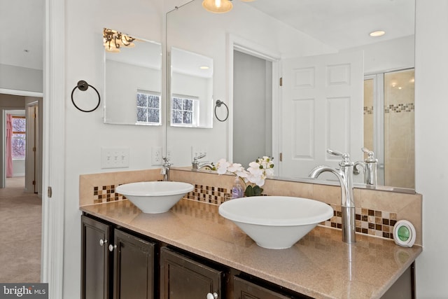 full bath with double vanity, decorative backsplash, and a sink