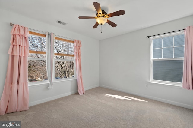 spare room with visible vents, baseboards, carpet, and ceiling fan