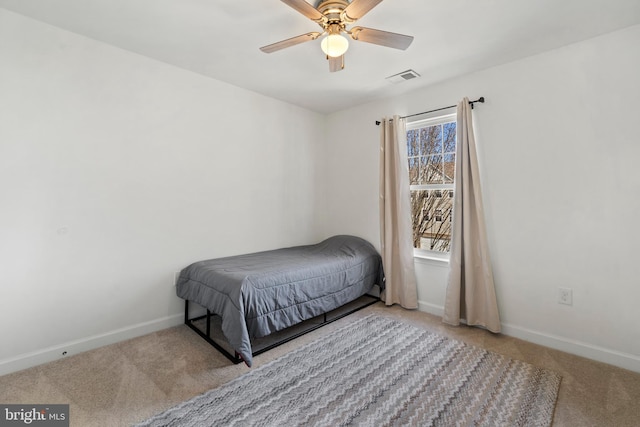 carpeted bedroom featuring visible vents, baseboards, and a ceiling fan