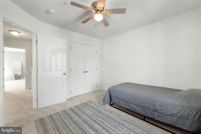 bedroom with a ceiling fan, a closet, and light carpet