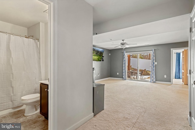 bathroom featuring curtained shower, baseboards, toilet, vanity, and a ceiling fan