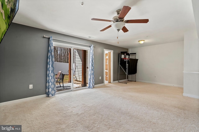 carpeted spare room featuring visible vents, baseboards, and ceiling fan