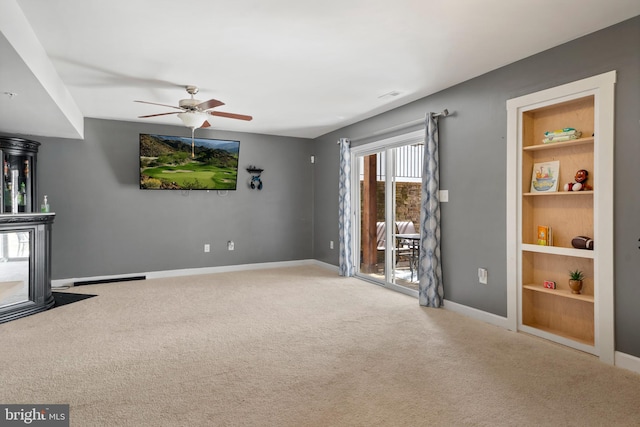 unfurnished living room with built in shelves, carpet, and baseboards