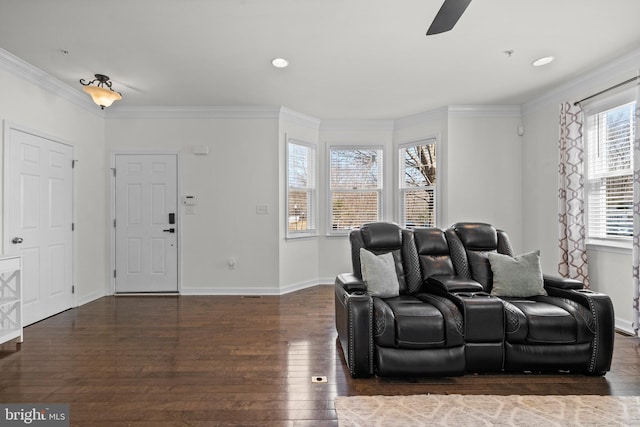 home theater room with baseboards, a ceiling fan, wood finished floors, and crown molding