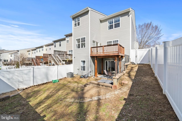 rear view of house with a fenced backyard, a wooden deck, central AC, and a gate