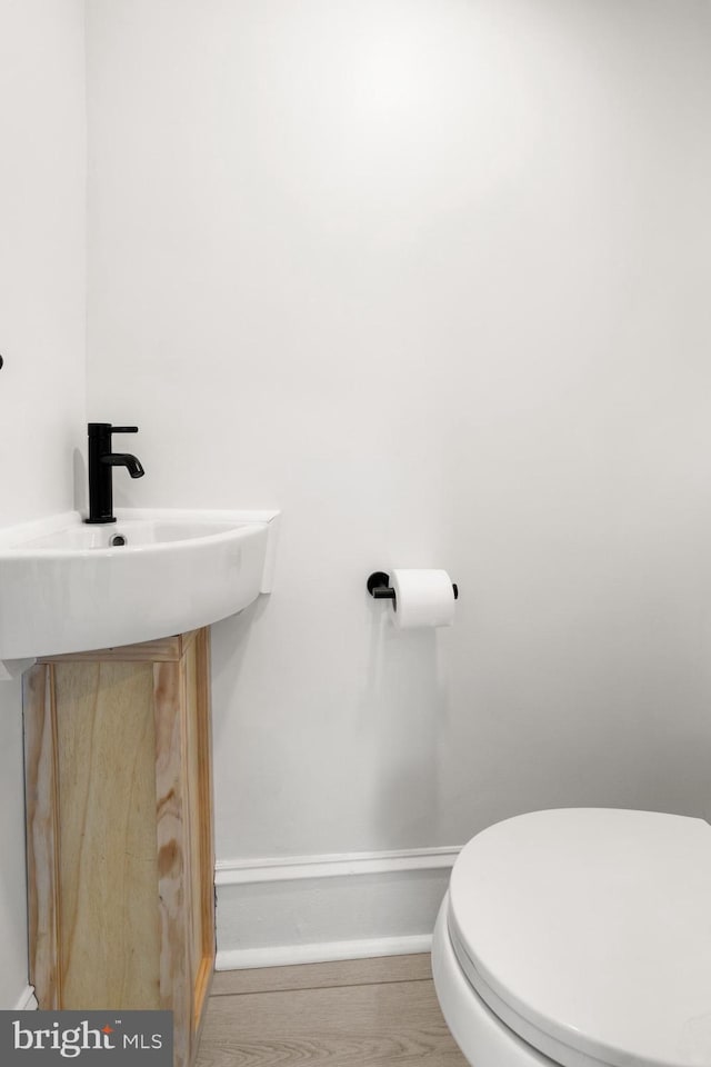 bathroom with hardwood / wood-style flooring and toilet