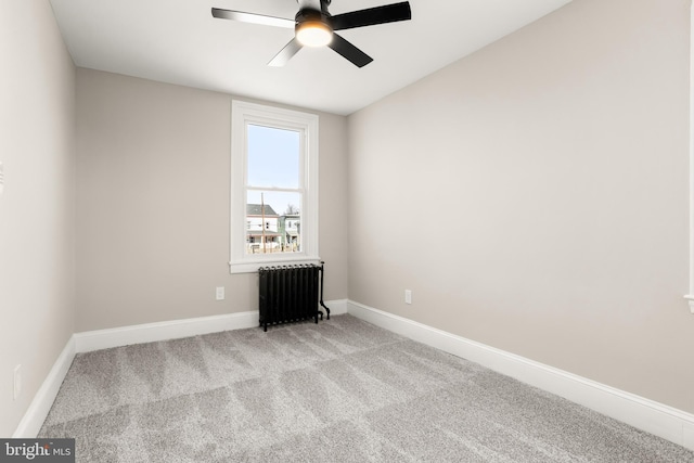 carpeted spare room featuring ceiling fan and radiator