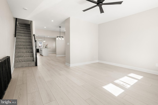 unfurnished room featuring ceiling fan, radiator, and light wood-type flooring