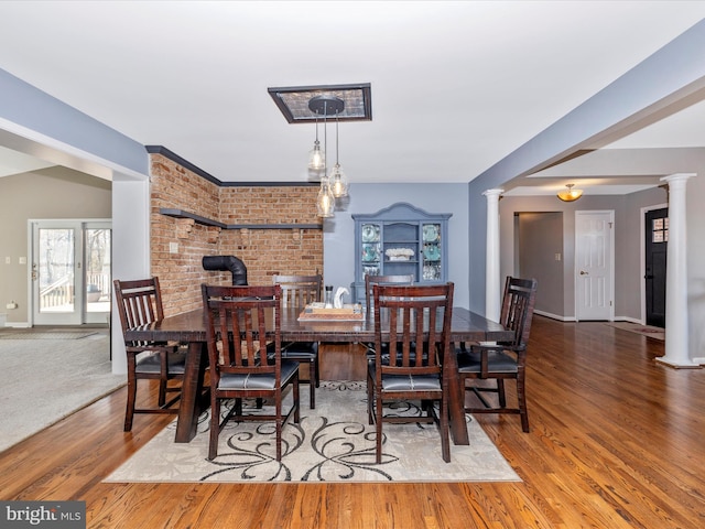 dining room with decorative columns and hardwood / wood-style floors