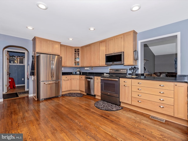 kitchen featuring hardwood / wood-style flooring, light brown cabinets, and appliances with stainless steel finishes