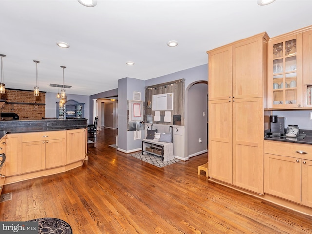 kitchen featuring wood-type flooring, decorative light fixtures, and light brown cabinetry