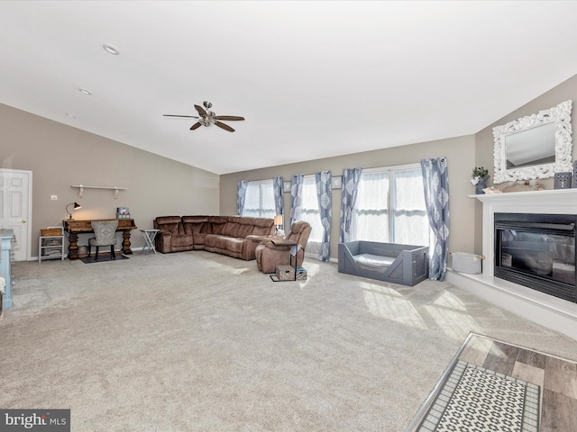 carpeted living room with lofted ceiling and ceiling fan