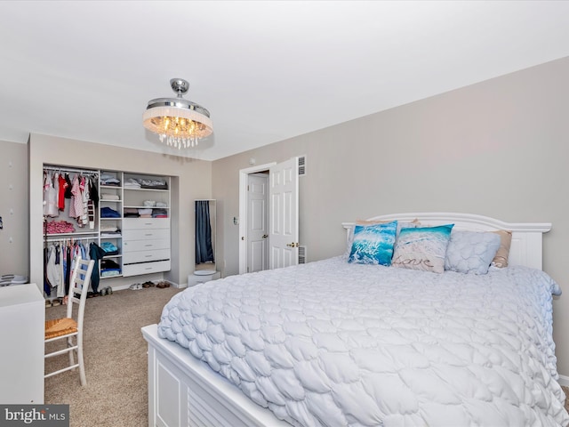 bedroom with carpet floors, a chandelier, and a closet