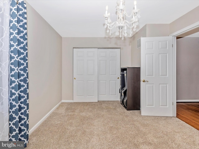 carpeted bedroom with a chandelier and a closet