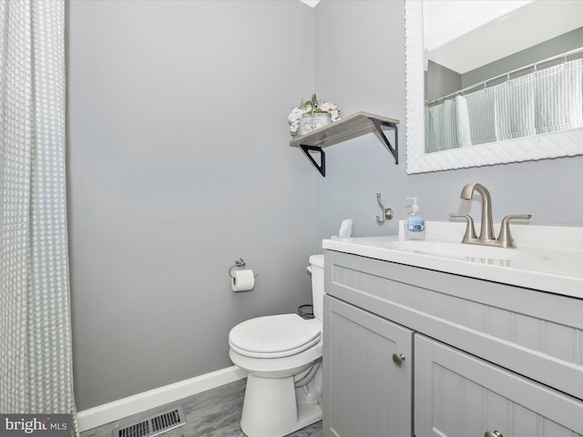 bathroom featuring vanity, hardwood / wood-style floors, and toilet